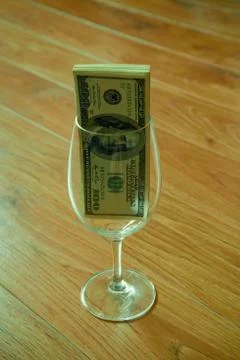 Dollars in wineglass Stock Photos
