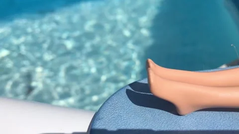 Dolls legs closeup at the pool Stockbeeldmateriaal 248846611