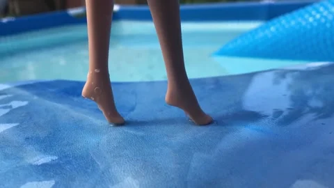 Dolls legs at the pool close up Stockbeeldmateriaal 248852633