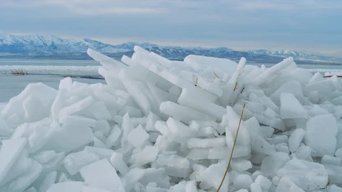 Dolly across large chunks of ice at freezing Utah Lake in winter slow motion Video stock 129417851