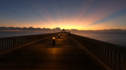 Dolly Along Deerfield Beach Pier Before Dawn Past Woman Taking Picture Stock Footage 217543012