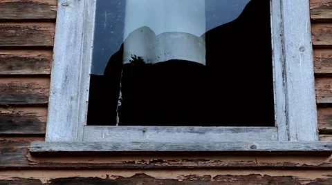Dolly in to broken window, curtains waving in the wind 動画素材 57473391