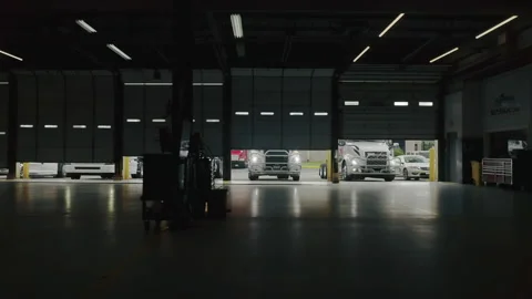 Dolly camera slider inside of empty garage doors, cargo trucks lined up loading Video stock 165510625