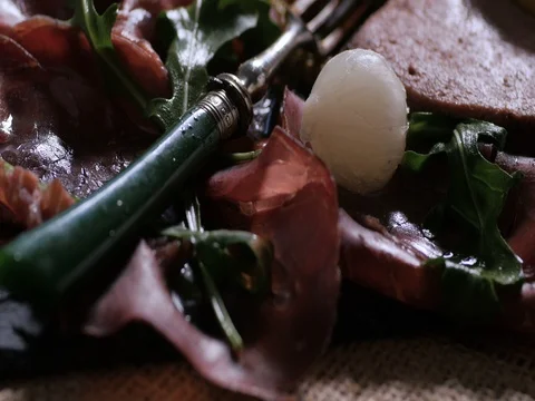 Dolly close up push in view of a platter of cured meat (charcuterie) Stock Footage 76443853