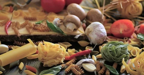 Dolly close up view of different variety of Italian pasta and ingredients Stock Footage 71355519