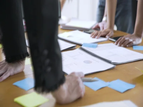 Dolly cropped hands of business people analyzing data in board room Stock Footage
