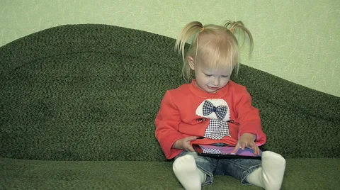 Dolly cute Girl sitting on the Couch at home with Tablet Stock Footage