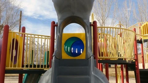 Dolly in to empty colorful playground equipment clouds in blue sky Stock Footage 72626195