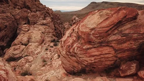 Dolly forward from behind large rock in Red Rock Canyon to reveal canyon Video stock 105020301