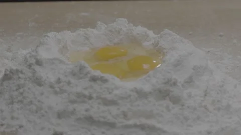 Dolly left to right of three eggs in a bowl of flour Stock-Footage 149107084