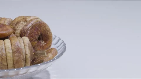 Dolly left shot of dried fig on plate, white background Stock Footage 280336847