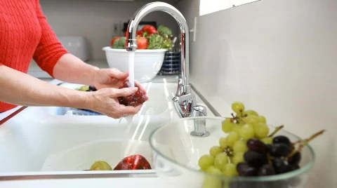 Dolly left woman washing fruit Stock Footage