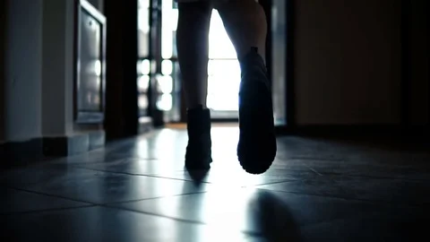 Dolly with low-section legs of silhouette woman running in corridor hallway 스톡 동영상 82862822
