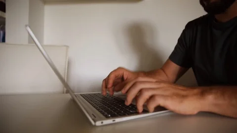 Dolly motion of a bearded man typing on laptop Stock Footage 112931730