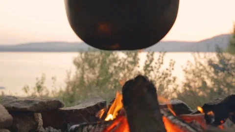 DOLLY MOTION: Cooking in a cauldron on fire Stock Footage 76194921