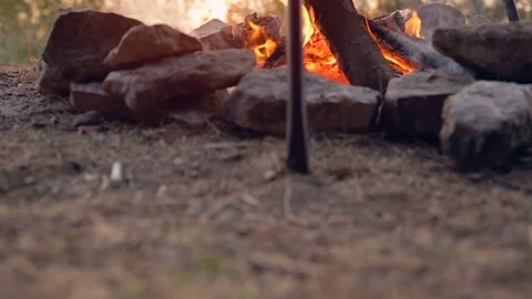 DOLLY MOTION: Cooking on fire at sunrise. Making coffee on the fire. Travel Gear Stock Footage 76194635