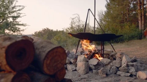 DOLLY MOTION: Cooking two dishes on fire. Food in the campaign. Journey to the 스톡 동영상 76194480