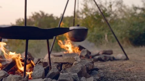 DOLLY MOTION: Cooking two dishes on fire. Food in the campaign. Journey to the Stock Footage 76200993