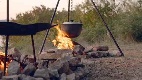 DOLLY MOTION: Cooking two dishes on fire. Food in the campaign. Journey to the Stockbeeldmateriaal 76201110