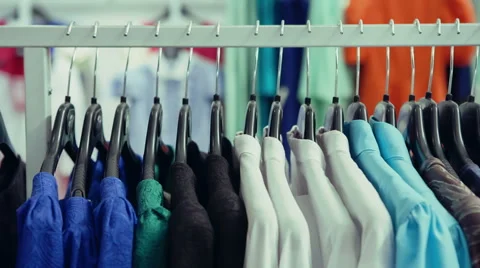 DOLLY MOTION: Variety of clothes hanging on rack in boutique Stock Footage
