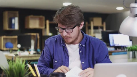 Dolly move of programmer worker working with documents at office Stock Footage 129912135