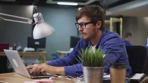 Dolly move of programmer working on computer in office Stock Footage 121772844