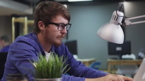 Dolly move of programmer working on computer in office Stock Footage 129917072