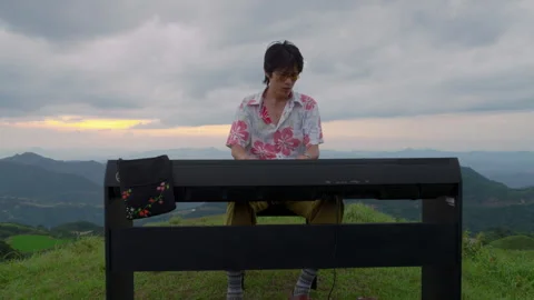 Dolly Out of Asian Man Creative Pianist Playing on Mountain Peak Sunset Stock Footage 340396079