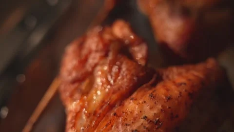 Dolly over shot of crispy roasted chicken wing on skewer close-up Stock Footage 312647842