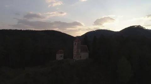 Dolly pan shot of old white chapel on the hill in the middle of the forest, 4K Stock Footage 74502196