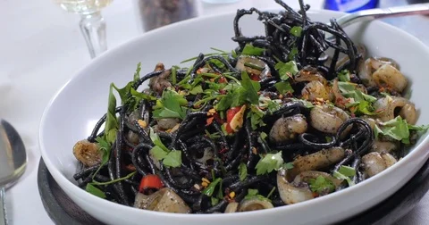 Dolly panning view of delicious black pasta with squids (cuttlefish) and ink Stock Footage 77332022
