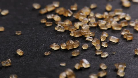 Dolly panorama of brown cane sugar on black background Stock Footage 254123397