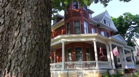 Dolly past a tree reveals the large Victorian Home Vidéo 39817555