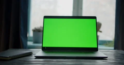 Dolly push in to laptop computer with green screen on a table in front of Stock Footage 146315611