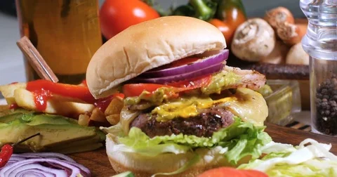 Dolly push out view of a delicious cheeseburger with French fries and beer Stock Footage 74569348