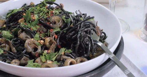 Dolly push out view of delicious black pasta with squids (cuttlefish) and ink Stock Footage 76447051