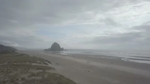 Dolly push in toward a large boulder right off the coast in the sea Stock Footage 167674660