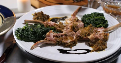 Dolly push in view of a rack of lamb with crusted mint sauce Stock Footage 73485645