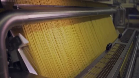 Dolly in of raw spaghetti pasta in a pasta factory in Italy. Stock Footage