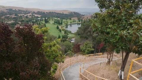 Dolly Up Reveal of Golf Course from Hillside Stairs Stock Footage 340878147