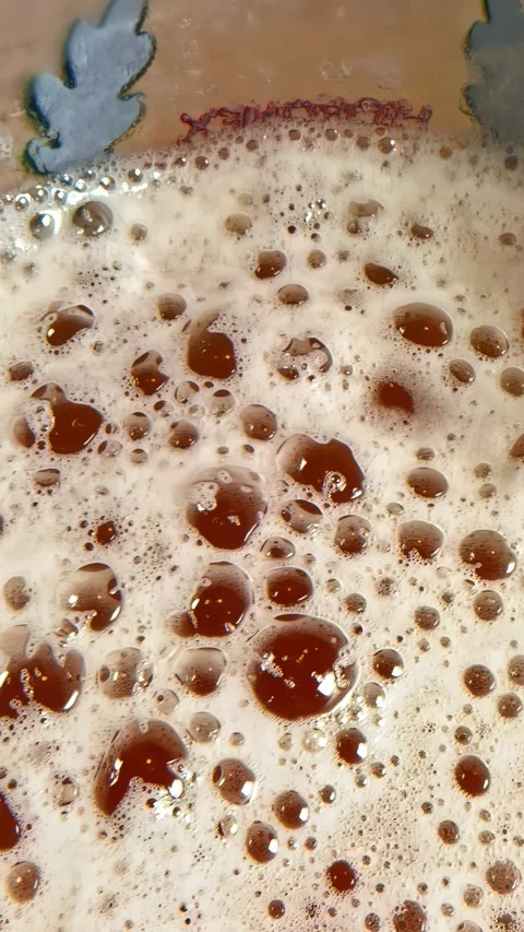 Dolly Right Over Frothy Dark Beer Surface with Amber Bubbles Capturing the Head Stock Footage 337195272