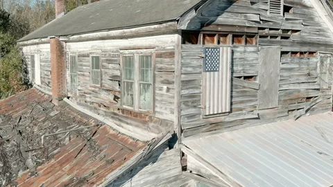 Dolly shot of abandoned general store with American flag Stock Footage 166307674