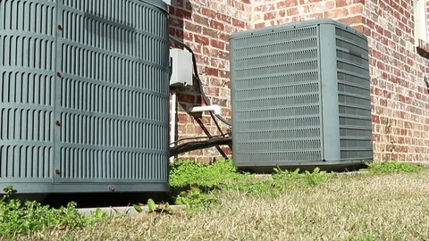 Dolly shot of air conditioner units next to brick home Stock Footage 101964524