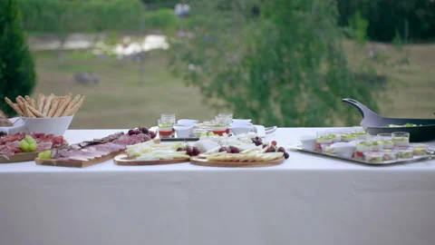 Dolly shot of appetizing banquet table outdoors decorated with fresh flowers Stock-Footage 158695776