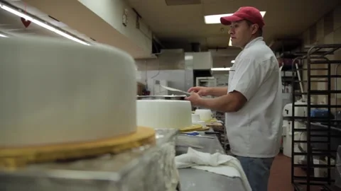 Dolly shot of a baker icing a cake Stock Footage 231414406
