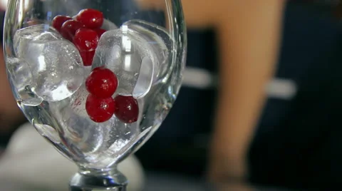 Dolly shot of the bartender pouring an empty glass with ice and cranberry Stock Footage 41776605