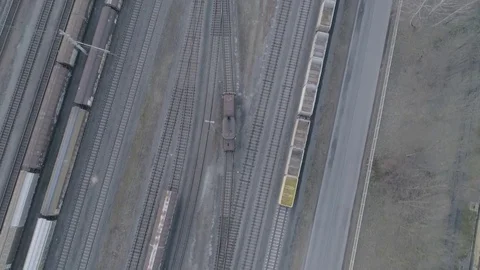Dolly shot bird view of a single locomotive driving thru a railroad system, 4K Stock Footage 73107697