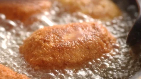 Dolly shot of Breaded Cutlets Sizzle in Frying Pan. Stock Footage 258651172