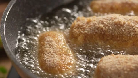 Dolly shot of Breaded Cutlets Sizzle in Frying Pan. Stock Footage 258651745