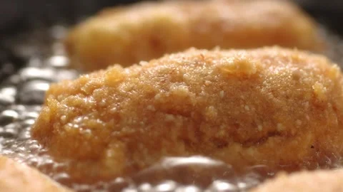 Dolly shot of Breaded Cutlets Sizzle in Frying Pan. Stock Footage 258651781